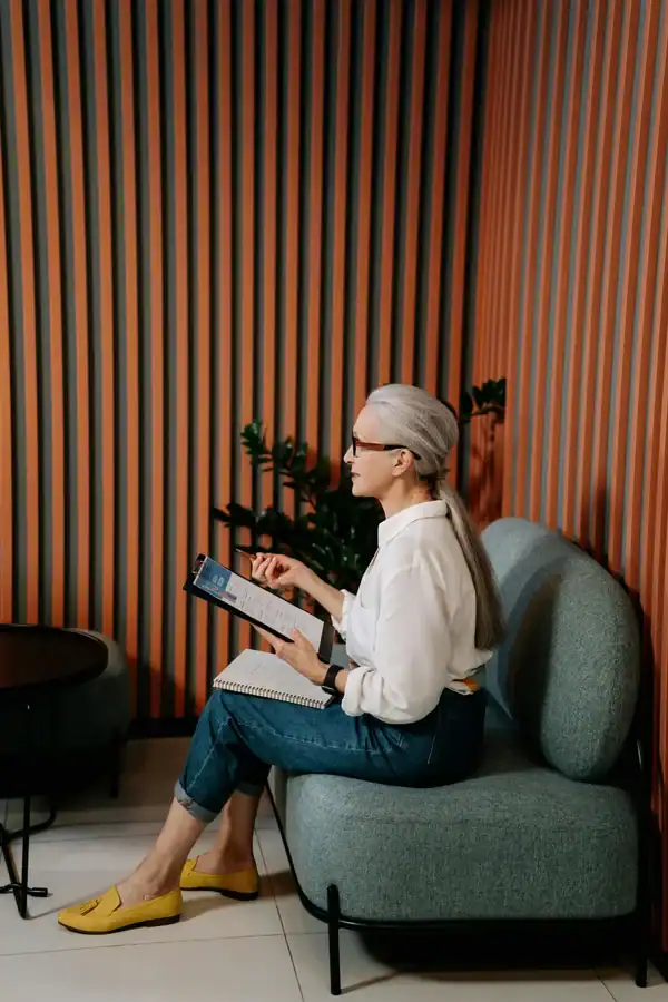 Personne assise, en train de discuter de comment bien recruter en 2025, avec une tablette